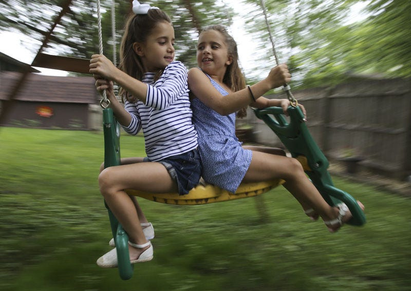 Sophia Moreno, who suffers from allergies and asthma, left, and her twin sister, Isabella, play together recently in the backyard of their home in Shorewood, Ill. A Northwestern study shows that trips to the ER and hospitalizations for kids with food allergies has tripled in Illinois. TNS Photo/Chicago Tribune, Antonio Perez