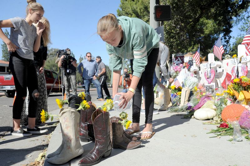 Haley Byron,11, waters flowers inside boots near the Borderline Bar & Grill in Thousand Oaks, where a memorial was set up for those killed in the Nov. 7, 2018 mass shooting.