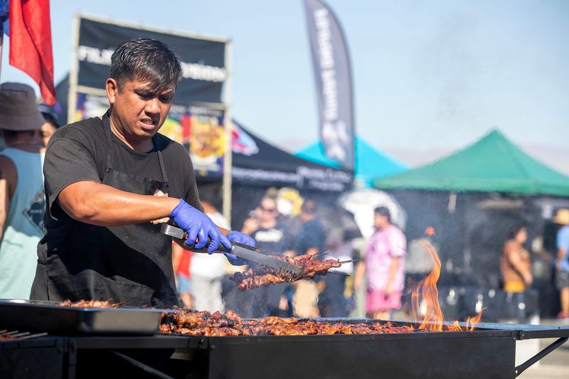 Ryan Felipe of Tatay Ry’s grills chicken and pork during the inaugural Coachella Valley Filipino Festival at the Palm Springs Cultural Center in Palm Springs, Calif., on Sunday, October 8, 2023.