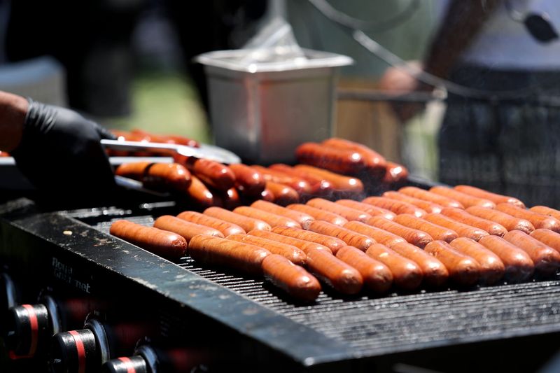 Hot dogs grill for attendees during a city-sponsored party to celebrate new playground equipment and large shade structure at Victoria Park in Palm Springs, Calif., on Wednesday, July 3, 2024.