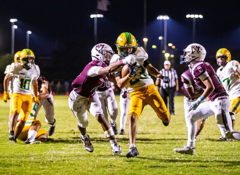 Coachella Valley's Aaron Ramirez breaks through Rancho Mirage's Kobee Finnikin (4) and Noah Hook (8) for a touchdown run during the fourth quarter of their game in Rancho Mirage, Calif., Saturday, Aug. 31, 2024.
