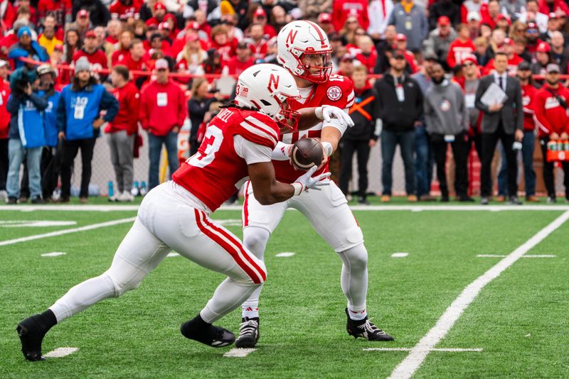 Nov 2, 2024; Lincoln, Nebraska, USA; Nebraska Cornhuskers quarterback Dylan Raiola (15) hands the ball off to running back Dante Dowdell (23) against the UCLA Bruins during the first quarter at Memorial Stadium. Mandatory Credit: Dylan Widger-Imagn Images