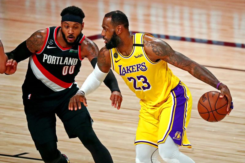 Aug 29, 2020; Lake Buena Vista, Florida, USA; Los Angeles Lakers forward LeBron James (23) handles the ball against Portland Trail Blazers forward Carmelo Anthony (00) during the second quarter in game five of the first round of the 2020 NBA Playoffs at AdventHealth Arena. Mandatory Credit: Kim Klement-USA TODAY Sports