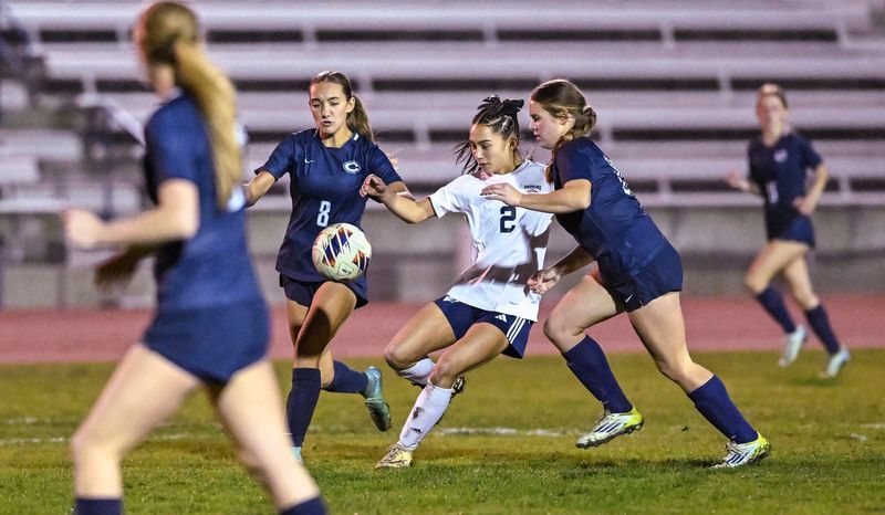 El Diamante's Brookelyn Bawanan battles between Central Valley Christian's Remy Aicklen, right, and Reagan Neese in non-league girls soccer on Thursday, December 12, 2024.