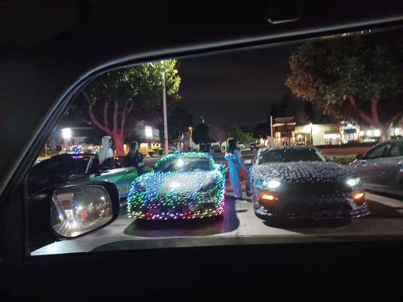 Cars covered with holiday lights are parked in December 2024 in Thousand Oaks. The California Highway Patrol says it's illegal to drive such cars in the state, citing Section 25252 of the California Vehicle Code.