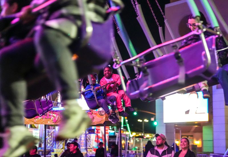 5-year-olds Ameir Thomas (left) and Ayva Zellous of Cathedral City ride a swing carousel during the Taste of Jalisco festival in Cathedral City, Calif., Friday, Jan. 31, 2025.