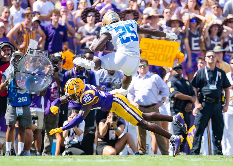 UCLA Bruins running back TJ Harden leaps over LSU Tiger Javien Toviano.