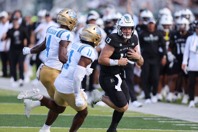 Aug 31, 2024; Honolulu, Hawaii, USA; Hawaii Rainbow Warriors quarterback Brayden Schager (13) is chased down by UCLA Bruins defensive back Bryan Addison (4) and defensive back Ramon Henderson (11) during the third quarter of an NCAA college football game against the UCLA Bruins at the Clarence T.C. Ching Athletics Complex. Mandatory Credit: Marco Garcia-USA TODAY Sports