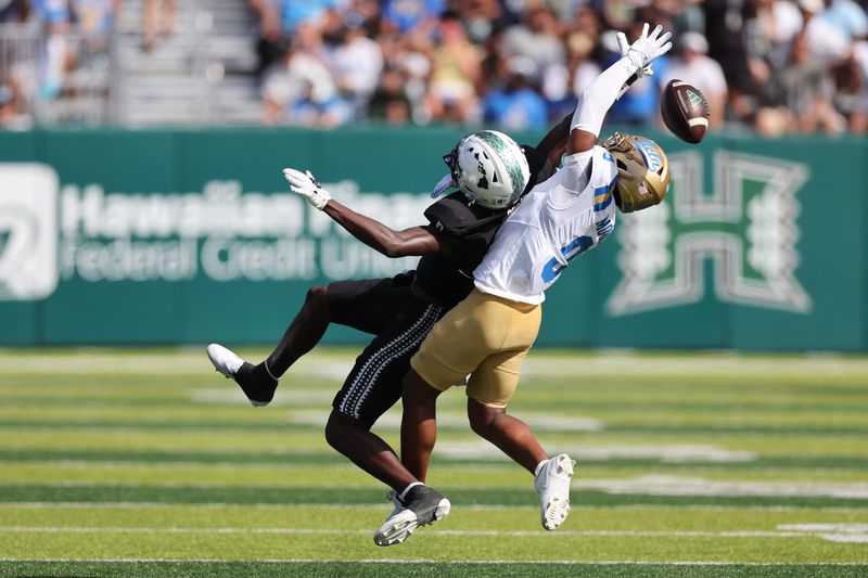 Aug 31, 2024; Honolulu, Hawaii, USA; Hawaii Rainbow Warriors wide receiver Alex Perry (0) can’t pull in a catch while being guarded by UCLA Bruins defensive back Kaylin Moore (9) during the third quarter of an NCAA college football game against the UCLA Bruins at the Clarence T.C. Ching Athletics Complex. Mandatory Credit: Marco Garcia-USA TODAY Sports