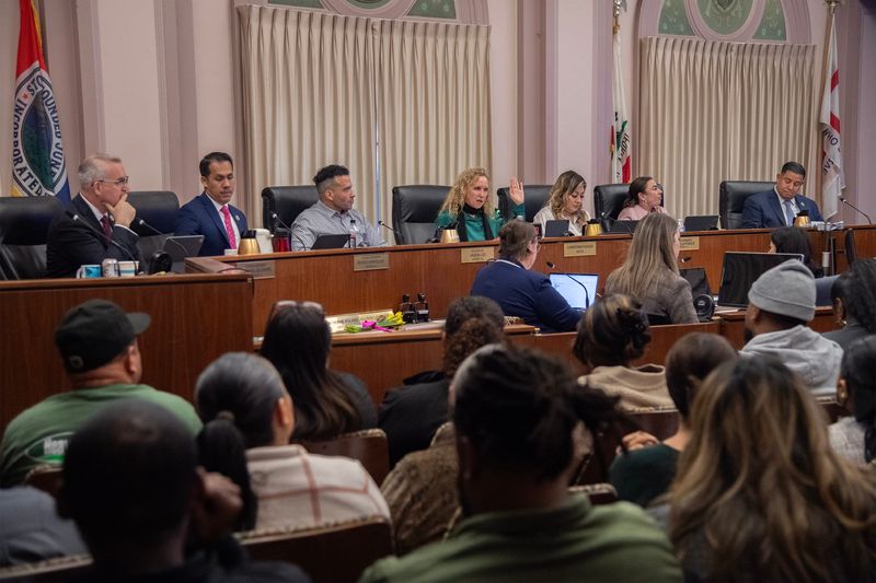 Council members Michael Blower, seated left, Mario Enríquez, Vice Mayor Jason Lee, Mayor Christina Fugazi, city council members Mariela Ponce, Michele Padilla and Brando Villapudua participate in a meeting at city hall in downtown Stockton.