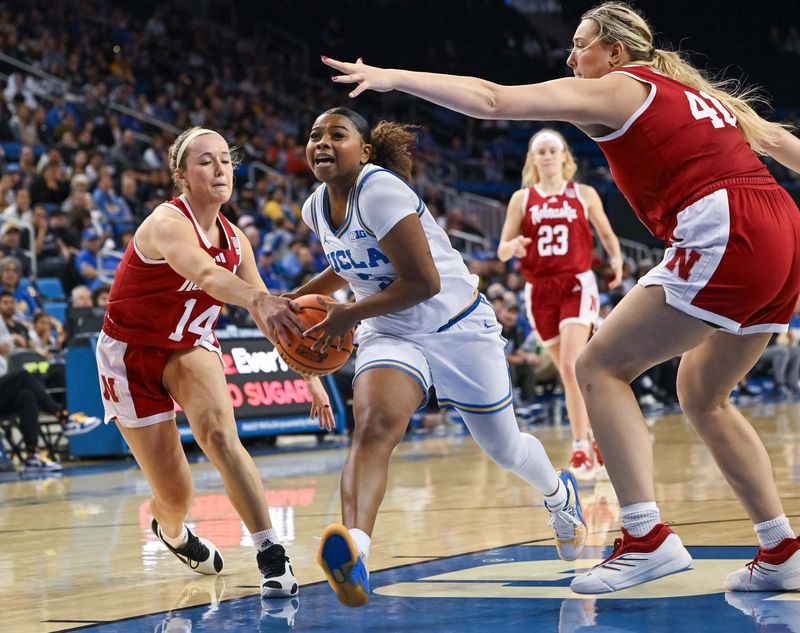Dec 29, 2024; Los Angeles, California, USA; UCLA Bruins guard Londynn Jones (3) drives to the basket between Nebraska Cornhuskers guard Callin Hake (14) and center Alexis Markowski (40) during the fourth quarter at Pauley Pavilion presented by Wescom. Mandatory Credit: Robert Hanashiro-Imagn Images