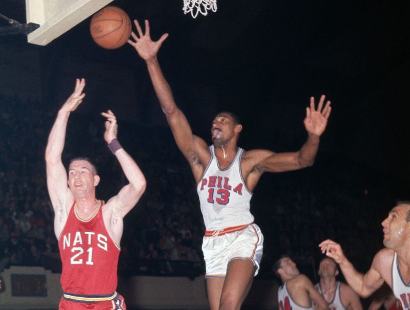 1962-Philadelphia, PA: Wilt Chamberlain (#13), steals the ball from the hands of Larry Costello of the Nationals as Costello comes in for a shot at the basket during a game between the Syracuse Nationals and the Philadelphia Warriors.