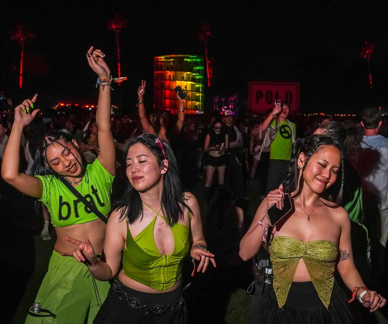 Jill Chiu (from left), Kimberly Thom and Emma Nguyen of Vancouver, British Columbia, dance together during Charli xcx's set at the Coachella stage during the Coachella Valley Music and Arts Festival in Indio, Calif., Saturday, April 12, 2025.