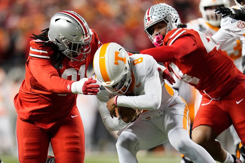 Ohio State Buckeyes defensive tackle Tyleik Williams (91) and defensive end JT Tuimoloau (44) sack Tennessee Volunteers quarterback Nico Iamaleava (8) during the first half of the College Football Playoff first round game at Ohio Stadium in Columbus on Dec. 21, 2024.