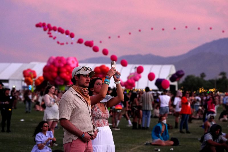 Santiago Corxes and Mercedes Sanchez of Mexico City watch Junior H perform on the Coachella Stage during the Coachella Valley Music and Arts Festival in Indio, Calif., on Sun., April 13, 2025.