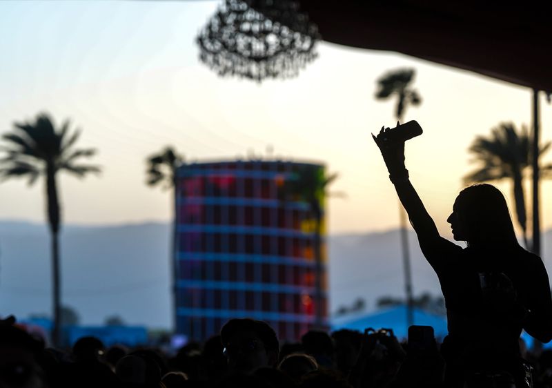 A festivalgoer dances while sitting on a friend's shoulders during A.G. Cook's set in the Gobi tent during the Coachella Valley Music and Arts Festival in Indio, Calif., Friday, April 18, 2025.