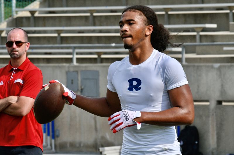 Redwood's Israel Briggs throws the football as Fresno State offensive coordinator Josh Davis looks on at the Redwood College Showcase on May 1 at Mineral King Bowl in Visalia.