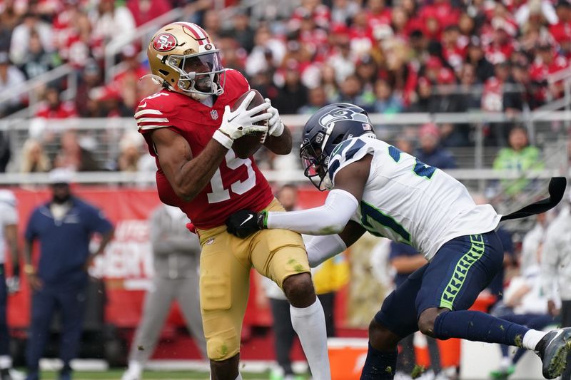 Nov 17, 2024; Santa Clara, California, USA; San Francisco 49ers wide receiver Jauan Jennings (15) makes a reception while defended by Seattle Seahawks cornerback Riq Woolen (27) in the third quarter at Levi's Stadium. Mandatory Credit: David Gonzales-Imagn Images