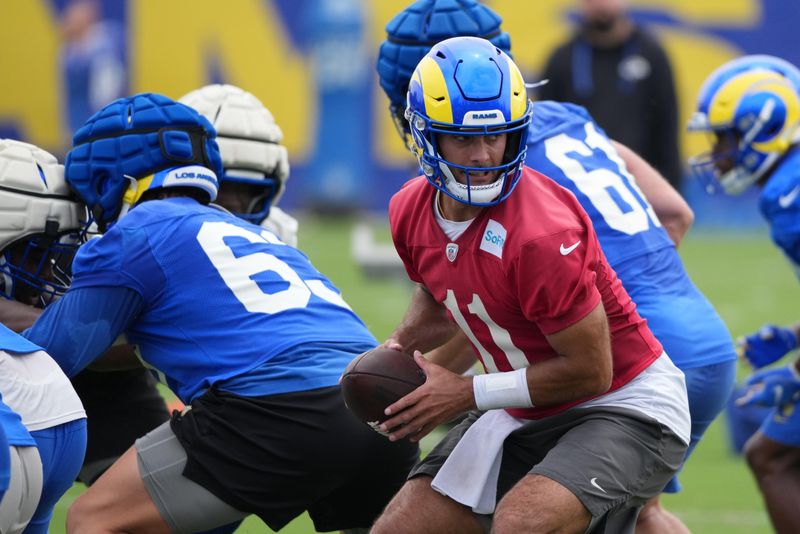May 28, 2025; Woodland Hills, CA, USA; Los Angeles Rams quarterback Jimmy Garoppolo (11) drops back after the snap during organized team activities at Rams Practice Facility. Mandatory Credit: Kirby Lee-Imagn Images