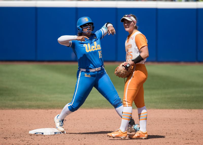 Jun 1, 2025; Oklahoma City, OK, USA; UCLA Bruins infielder Jordan Woolery (15) celebrates after hitting a double as Tennessee Lady Volunteers infielder Ella Dodge (25) looks on during the NCAA Softball Women's College World Series at Devon Park. Mandatory Credit: Brett Rojo-Imagn Images