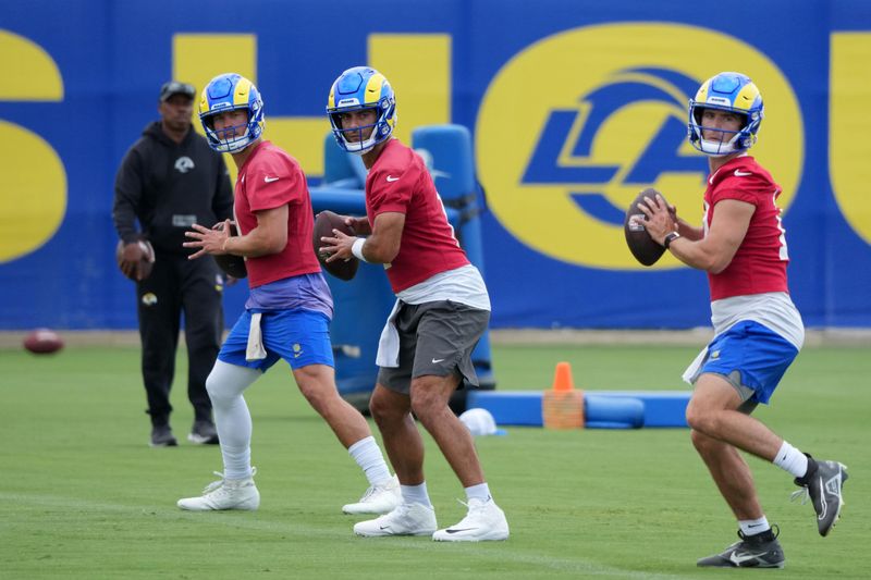 Jun 3, 2025; Woodland Hills, CA, USA; Los Angeles Rams quarterbacks Matthew Stafford (left), Jimmy Garoppolo (center) and Stetson Bennett throw the ball during organized team activities at Rams Practice Facility. Mandatory Credit: Kirby Lee-Imagn Images