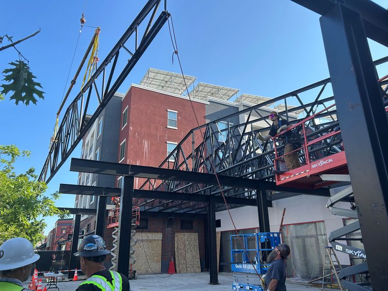 One of the trusses for Redding Public Market's outdoor patio is hoisted by a crane on the morning of Friday, June 6, 2025.