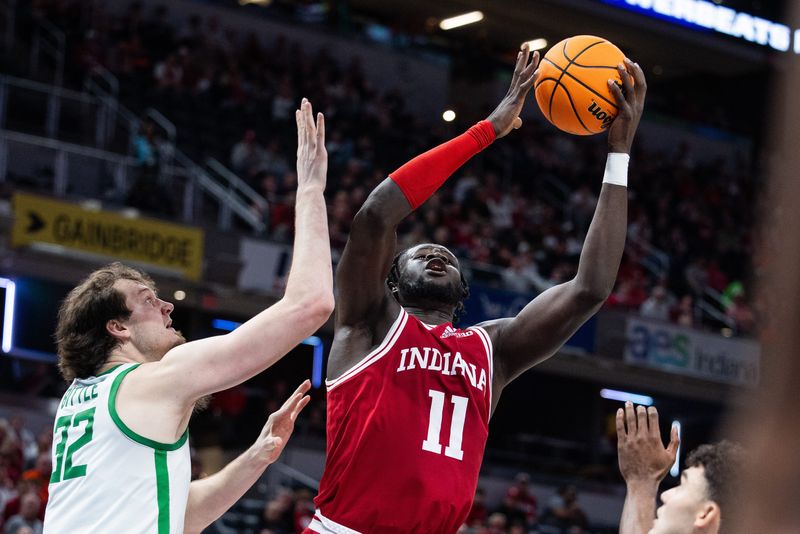 Mar 13, 2025; Indianapolis, IN, USA; Indiana Hoosiers center Oumar Ballo (11) shoots the ball while Oregon Ducks center Nate Bittle (32) defends in the first half at Gainbridge Fieldhouse. Mandatory Credit: Trevor Ruszkowski-Imagn Images