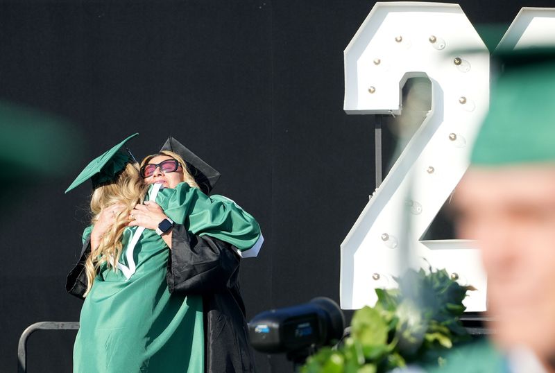 Helena Krostag, bilingual facilitator at Thousand Oaks High School, hugs her daughter Juliana Krostag during the graduation ceremony on the football field on June 11, 2025.