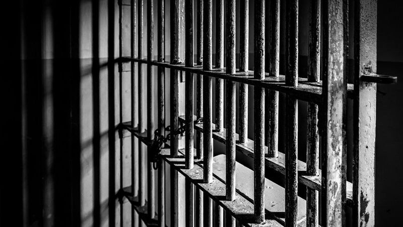 Jail bars in a jail cell stock photo.