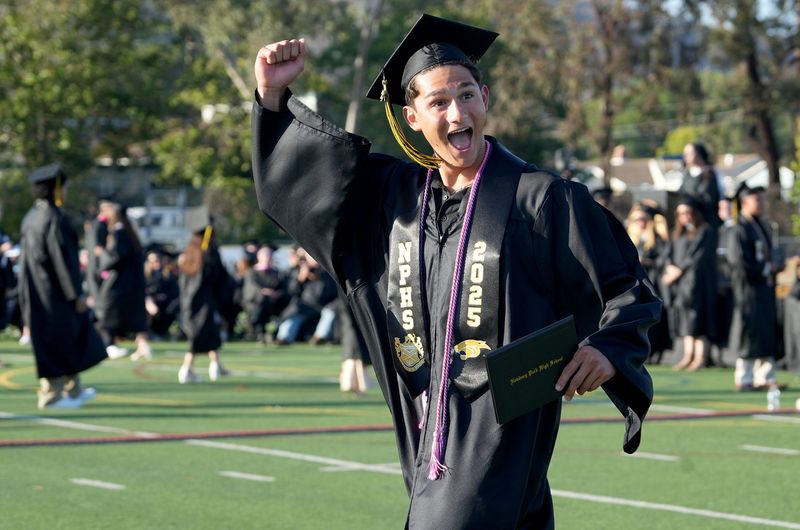 Tai Ortiz of Newbury Park High School celebrates after receiving his diploma during the graduation ceremony on the football field on June 13, 2025.