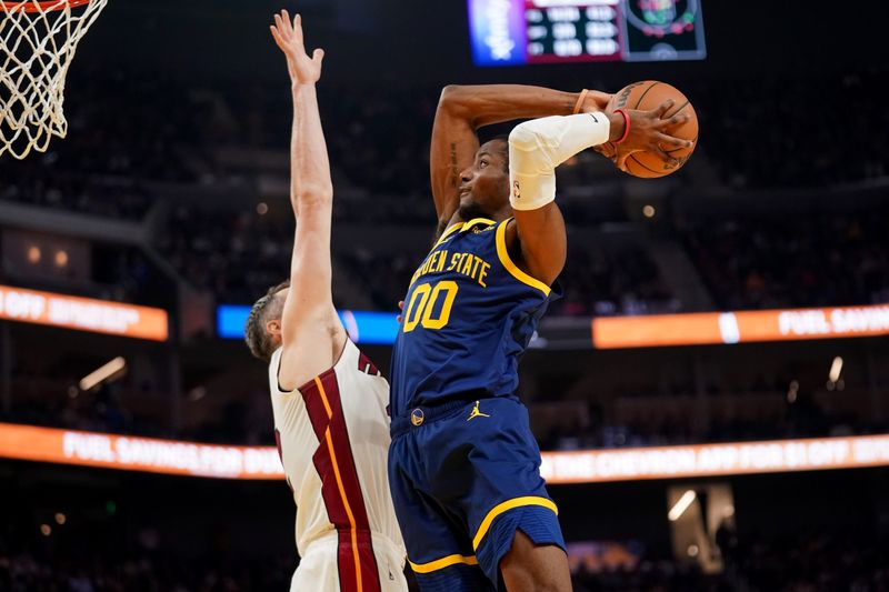 Dec 28, 2023; San Francisco, California, USA; Golden State Warriors forward Jonathan Kuminga (00) dunks the ball over Miami Heat forward Kevin Love (42) in the second quarter at the Chase Center. Mandatory Credit: Cary Edmondson-USA TODAY Sports