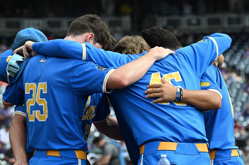 Jun 17, 2025; Omaha, Neb, USA; UCLA Bruins players huddle before the restart of the game against the LSU Tigers at Charles Schwab Field. Mandatory Credit: Steven Branscombe-Imagn Images