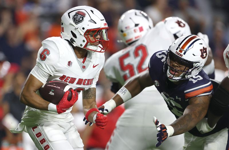 Sep 14, 2024; Auburn, Alabama, USA; Auburn Tigers defensive lineman Keldric Faulk (15) dives to tackle New Mexico Lobos running back Eli Sanders (6) during the second quarter at Jordan-Hare Stadium. Mandatory Credit: John Reed-Imagn Images