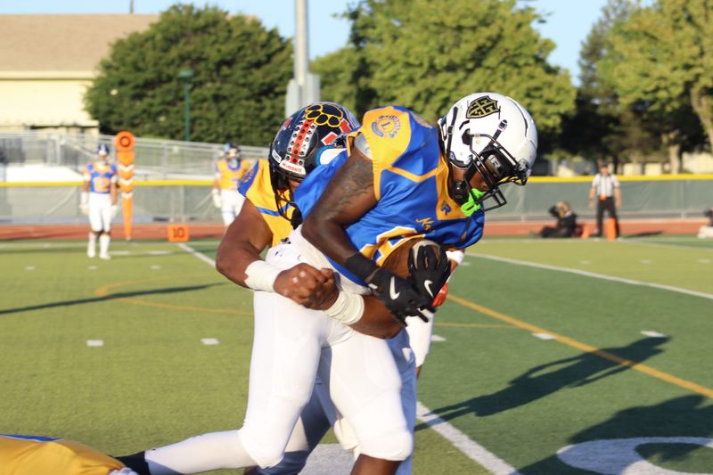 North tight end Treavon Spivey of Chavez tries to break free from the grasp of South linebacker MJ Uili in Saturday's 49th annual Lions 4A-1 All-Star Game at Wayne Schneider Stadium at Tracy High.