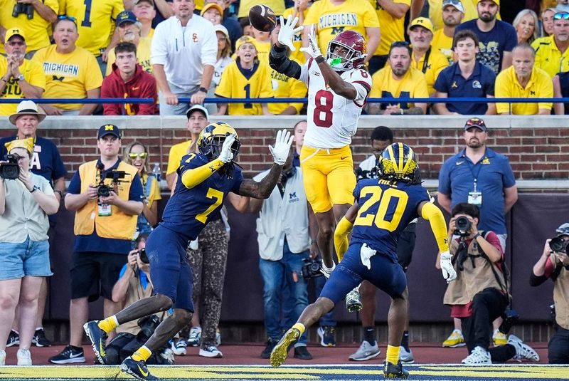 USC wide receiver Ja'Kobi Lane (8) makes a catch for a touchdown against Michigan defensive back Makari Paige (7) and defensive back Jyaire Hill (20) during the second half at Michigan Stadium in Ann Arbor on Saturday, Sept. 21, 2024.