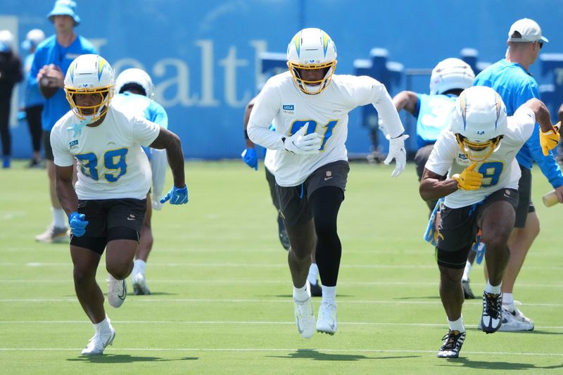 May 27, 2025; El Segundo, CA, USA; Los Angeles Chargers receivers Jaylen Johnson (39), Mike Williams (81) and receiver Tre Harris (9) during organized team activities at The Bolt. Mandatory Credit: Kirby Lee-Imagn Images