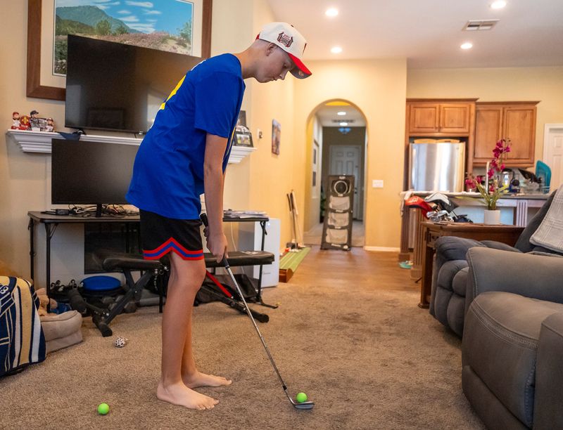 Johnny Brande, 15, works on his short game about a week after his last chemotherapy session at his family's home in Palm Desert, Calif., Wednesday, June 25, 2025. Brande has Ewing Sarcoma, a rare form of bone cancer that primarily affects young people. About 200 kids and teens are diagnosed with the disease each year in the United States, making up about 1% of all childhood cancer cases in the country according to the American Cancer Society.