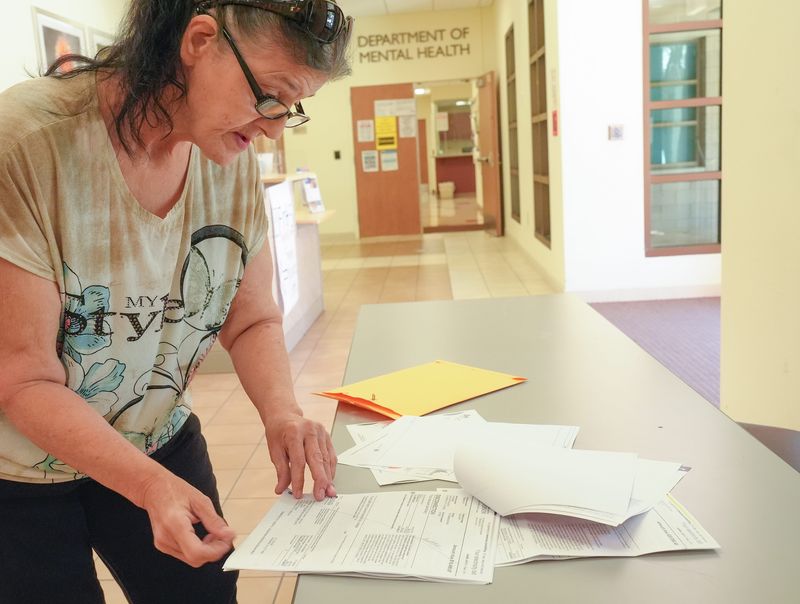 Tuesday Adams of Cathedral City looks over her $20,000 electric bill while seeking help at the Community Action Partnership of Riverside County in Desert Hot Springs, Calif., June 25, 2025.