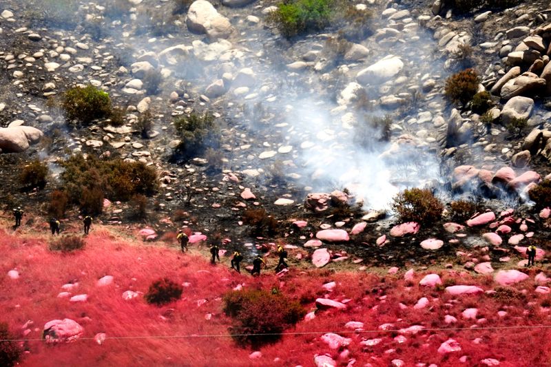A firefighting ground crew works to create a fire line to contain the Wolf Fire near Highway 243 in Banning, Calif., on Monday, June 30, 2025.