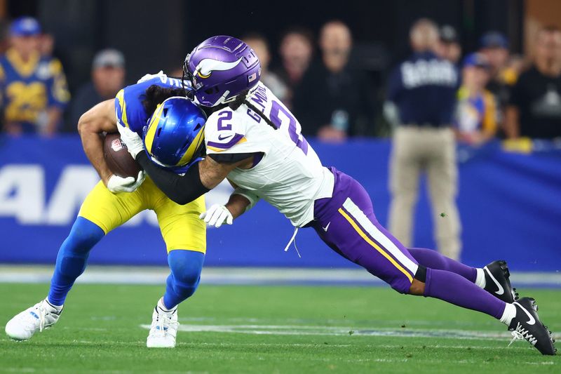 Jan 13, 2025; Glendale, AZ, USA; Los Angeles Rams wide receiver Puka Nacua (17) makes a catch against Minnesota Vikings cornerback Stephon Gilmore (2) during the second half in an NFC wild card game at State Farm Stadium. Mandatory Credit: Mark J. Rebilas-Imagn Images