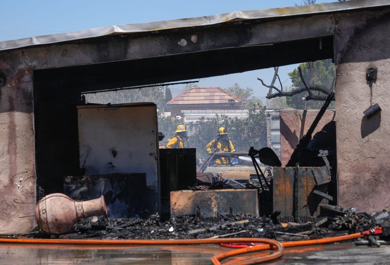Firefighters work to extinguish the smoldering remains in the backyard of a home on La Vida Dr. in the Windy Point area in northwest Palm Springs, Calif., July 7, 2025.