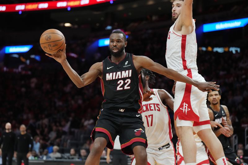 Mar 21, 2025; Miami, Florida, USA; Miami Heat forward Andrew Wiggins (22) grabs a rebound as Houston Rockets center Alperen Sengun (28) looks on in the second half at Kaseya Center. Mandatory Credit: Jim Rassol-Imagn Images