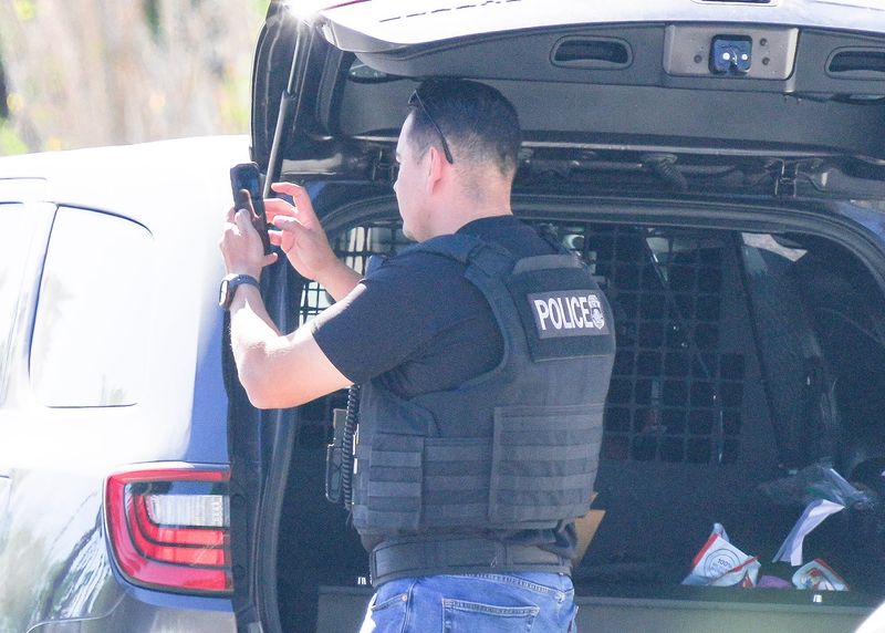 An ICE officer takes photos after detaining a man on the 1400 block of Sunny Dunes Rd. in Palm Springs, Calif., July 10, 2025.