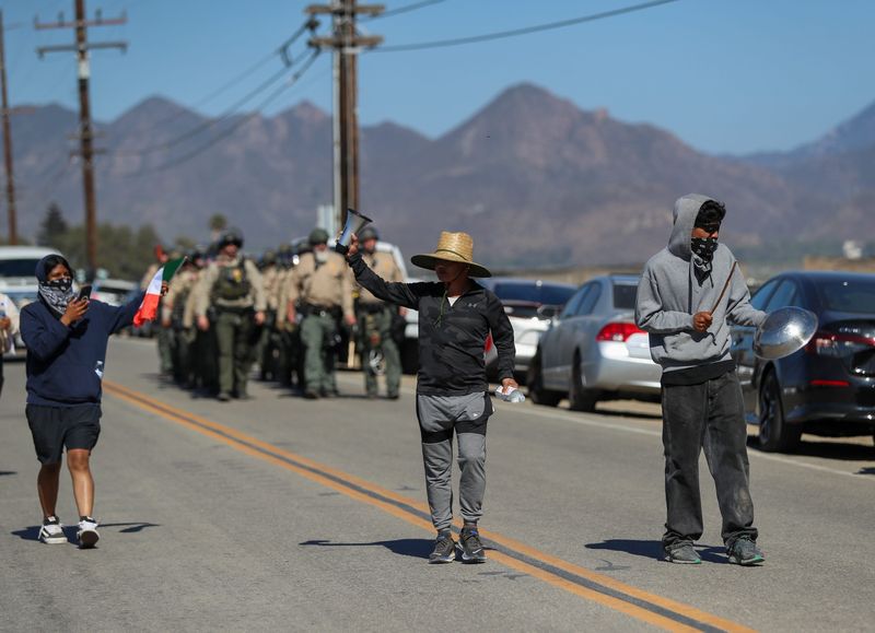 Protesters make noise to signal the arrival of Ventura County Sheriff's deputies at the intersection of Laguna and Wood roads during a July 10 raid at Glass House Farms near Camarillo. Most county law enforcement agencies say they are no longer getting notified when Immigration and Customs Enforcement officers are coming to the area.