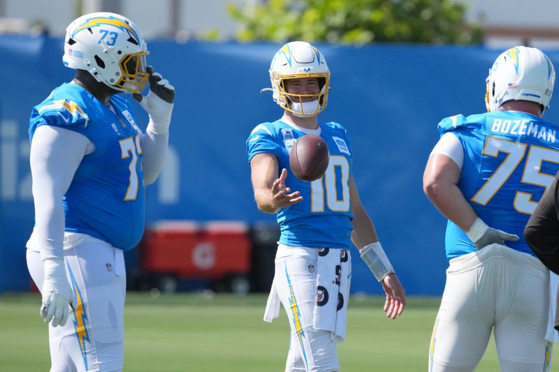 Jul 17, 2025; El Segundo, CA, USA; Los Angeles Chargers quarterback Justin Herbert (10) talks with guard Mekhi Becton (73) and center Bradley Bozeman (75) during training camp at The Bolt. Mandatory Credit: Kirby Lee-Imagn Images