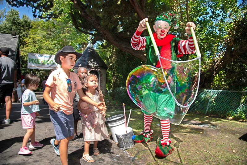 Sparkles the Clown creates soap bubbles for children at the annual Christmas in July event at Pixie Woods in Stockton on Jul. 26, 2025.