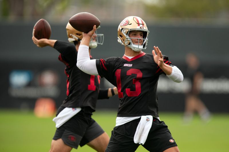Jul 24, 2025; Santa Clara, CA, USA; San Francisco 49ers quarterbacks Tanner Mordecai (14) and Brock Purdy (13) throw during a passing drill on the second day of training camp. Mandatory Credit: D. Ross Cameron-Imagn Images