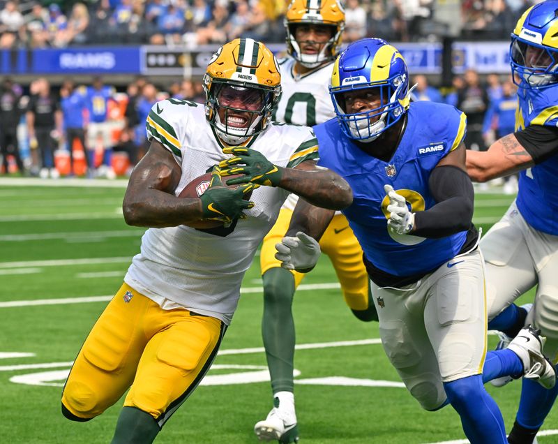 Oct 6, 2024; Inglewood, California, USA; Green Bay Packers running back Josh Jacobs (8) sprints to the end zone past Los Angeles Rams linebacker Jared Verse (8) to score a touchdown in the first quarter at SoFi Stadium. Mandatory Credit: Robert Hanashiro-Imagn Images