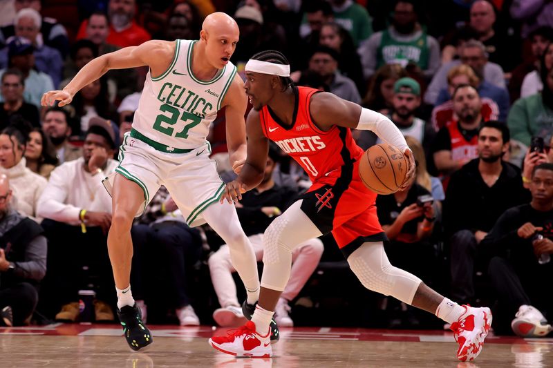 Jan 3, 2025; Houston, Texas, USA; Houston Rockets guard Aaron Holiday (0) handles the ball against Boston Celtics guard Jordan Walsh (27) during the game at Toyota Center. Mandatory Credit: Erik Williams-Imagn Images