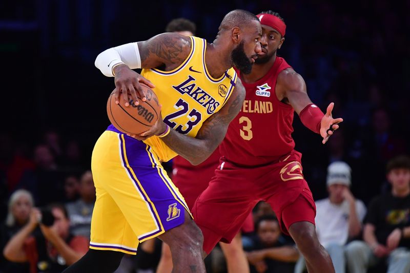Dec 31, 2024; Los Angeles, California, USA; Los Angeles Lakers forward LeBron James (23) controls the ball against Cleveland Cavaliers guard Caris LeVert (3) during the second half at Crypto.com Arena. Mandatory Credit: Gary A. Vasquez-Imagn Images